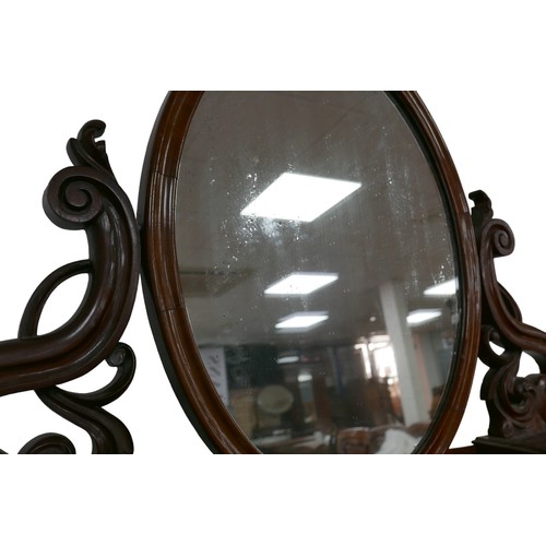 265 - A Victorian mahogany dressing table, its hinged oval mirror with shaped supports, two banks of six s... 