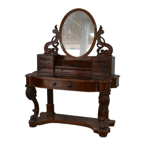 265 - A Victorian mahogany dressing table, its hinged oval mirror with shaped supports, two banks of six s... 