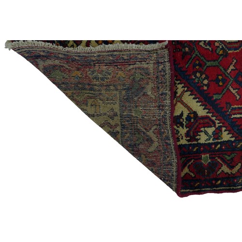 248 - A Hamadan rug, on red ground, densely decorated field with floral and foliate detail, blue diamond m... 