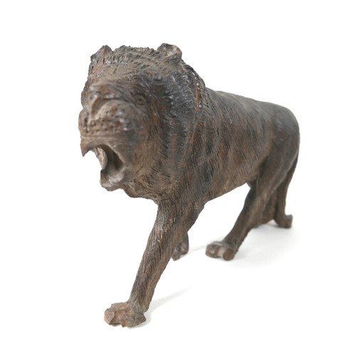 137 - A 19th century carved wooden sculpture of a lion, 24 by 7.5 by 16.5cm high.
