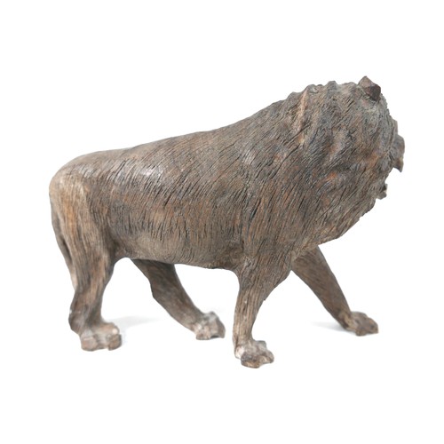 137 - A 19th century carved wooden sculpture of a lion, 24 by 7.5 by 16.5cm high.
