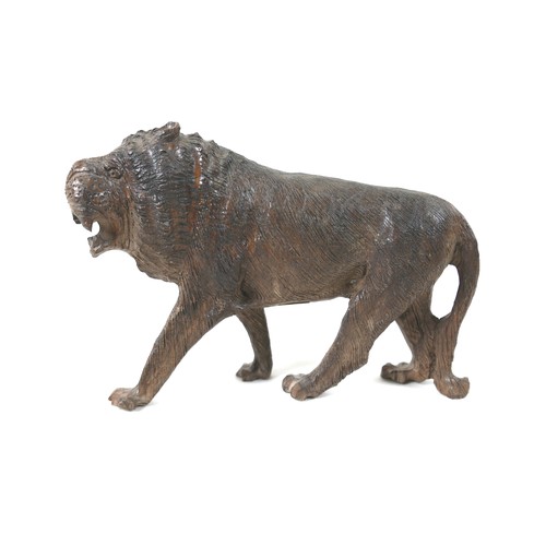 137 - A 19th century carved wooden sculpture of a lion, 24 by 7.5 by 16.5cm high.