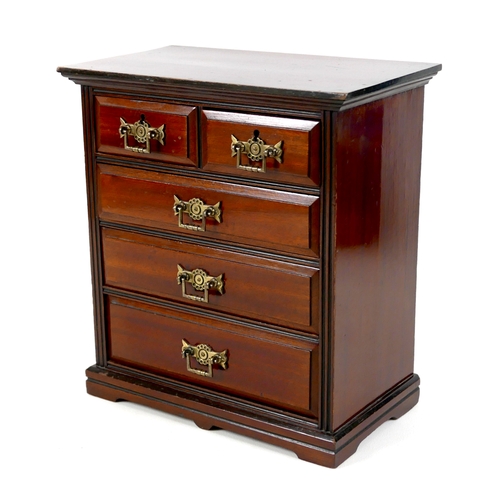 142 - A miniature Edwardian chest of drawers, brass handles, 32 by 18 by 34.5cm high.