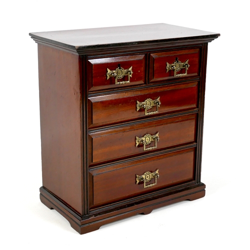 142 - A miniature Edwardian chest of drawers, brass handles, 32 by 18 by 34.5cm high.