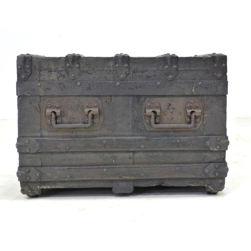 132 - A late Victorian or Edwardian trunk, the wooden carcass bound in dark metal and wooden batons, with ... 