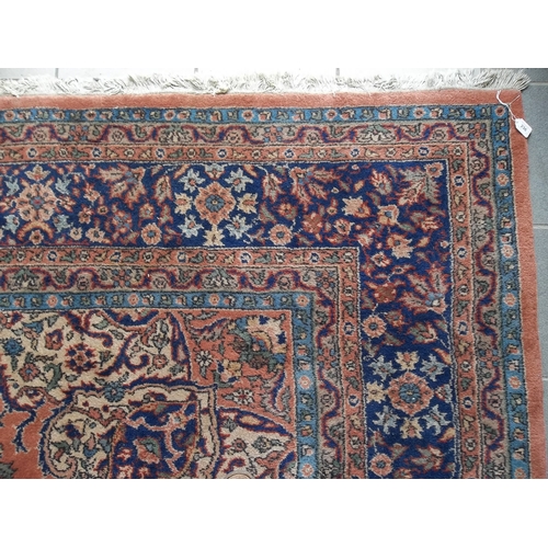 269 - A hand knotted Persian carpet, with pink ground and filled arabesque floral field, floral eight band... 