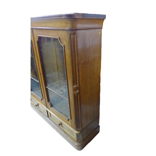 345 - A French late 19th century oak bookcase, twin glazed doors enclosing shelves, over two drawers below... 