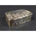 A Victorian silver box, the hinged cover embossed with a village scene depicting five standing figur... 