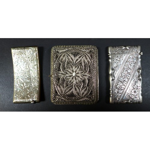 31 - A group of three silver card cases, one curved with full width hinged tapering cover, engraved folia... 