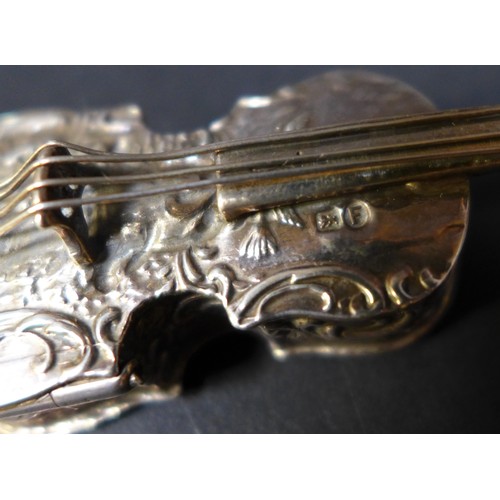 19 - A late 19th century Hanau silver novelty box, in the form of a violin, with embossed decoration of m... 