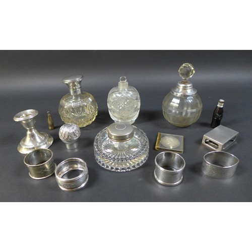 13 - A group of four silver topped cut glass dressing table bottles, largest 14cm high, a silver matchbox... 