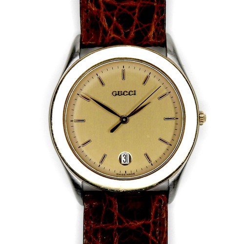 102 - A Gucci gold plated wristwatch, circular ivory coloured dial with gold batons, centre seconds, gold ... 