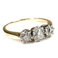 A gold and diamond stone ring, the central largest old European cut stone, 5.1 by 3.3mm, flanked by ... 