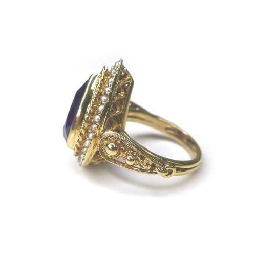 226 - An amethyst and seed pearl 9ct gold dress ring, pear cut amethyst 8 by 14mm, encircled by seed pearl... 