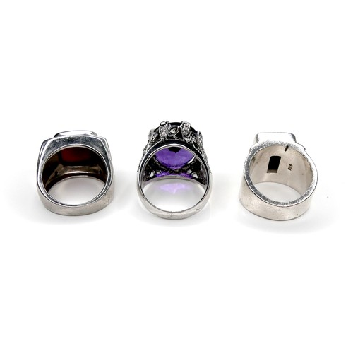 200 - A group of three silver rings, one set with a large amethyst, 20 by 17 by 10mm, size X, 14.8g, one s... 