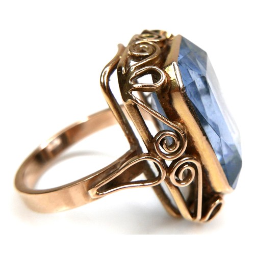 197 - An unmarked yellow gold dress ring, set with an emerald cut blue stone, probably blue topaz, 18.5 by... 