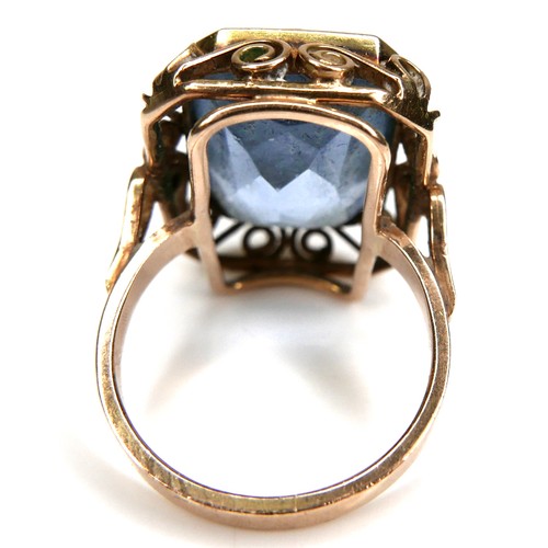 197 - An unmarked yellow gold dress ring, set with an emerald cut blue stone, probably blue topaz, 18.5 by... 