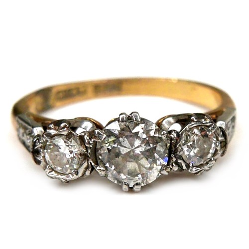 291 - An 18ct yellow gold, platinum, and diamond three stone ring, the central largest round brilliant cut... 