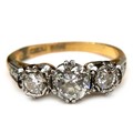 An 18ct yellow gold, platinum, and diamond three stone ring, the central largest round brilliant cut... 