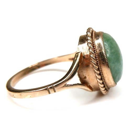 178 - A 9ct yellow gold and jade set ring, the oval cabochon cut jade 11.8 by 9.8mm, in rub over setting w... 