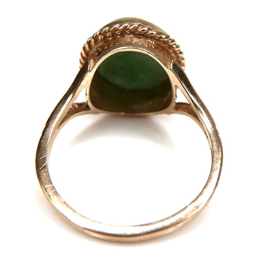 178 - A 9ct yellow gold and jade set ring, the oval cabochon cut jade 11.8 by 9.8mm, in rub over setting w... 