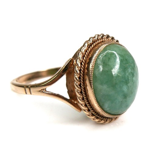 178 - A 9ct yellow gold and jade set ring, the oval cabochon cut jade 11.8 by 9.8mm, in rub over setting w... 