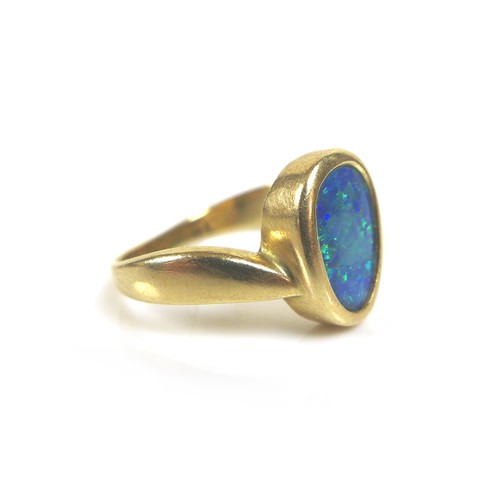 216 - A 14k yellow gold and opal ring, the oviform shaped opal in rub over setting, 10.5 by 7.0mm, on wide... 