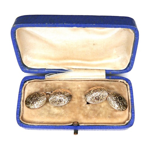 179 - A pair of Victorian 9ct yellow gold cufflinks, of convex oval form with chain links and engraved flo... 