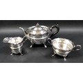 A George V three piece silver tea set, comprising teapot with ebony handle and finial and a flared s... 