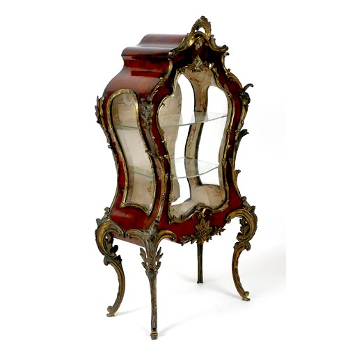 An early 19th century, Louis XV style, miniature tortoiseshell veneered vitrine cabinet, with ormolu mounts, bombe form glazed front and sides, shaped door to back accessing two glass shelves, raised upon gilt metal scroll legs, 30 by 17 by 61cm high.

Provenance: Privately owned and once housed a collection of Queen Elizabeth II doll's house furniture.