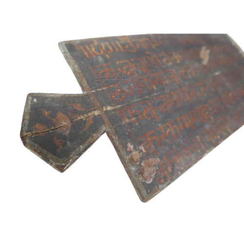 87 - An Indonesian board with single handle and a paper covering, with a handwritten script to one side, ... 