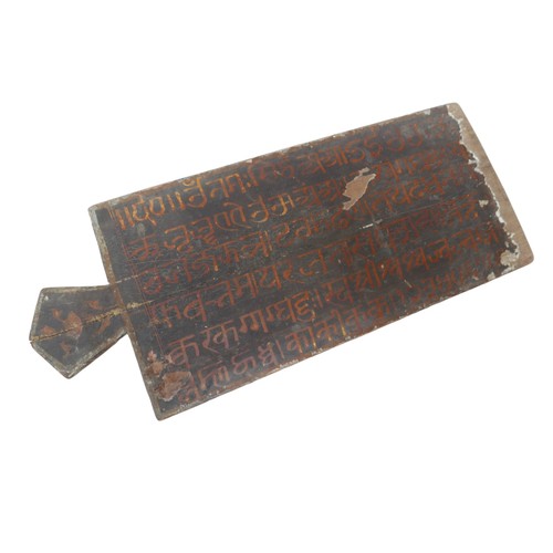 87 - An Indonesian board with single handle and a paper covering, with a handwritten script to one side, ... 