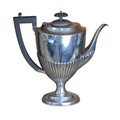 A George V silver coffee pot, with ebony handle and finial, gadrooned lower, and raised on an oval f... 