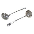 A large 19th century old English pattern silver ladle and a white metal ladle, with heavily rubbed h... 