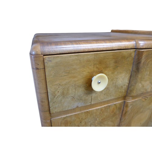 432 - An Art Deco walnut veneered sideboard, the breakfront with two frieze drawers with circular bakelite... 