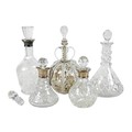 A group of cut glass decanters, three with silver collars, one a cut crystal three ring ship's style... 