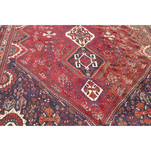 424 - A Hamadan rug, with red ground and floral decoration, 303 by 220cm.