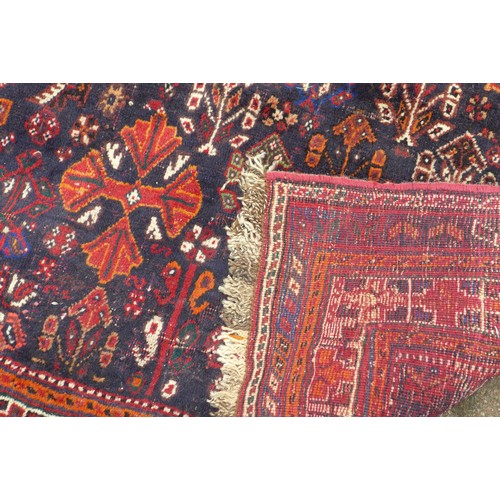 424 - A Hamadan rug, with red ground and floral decoration, 303 by 220cm.