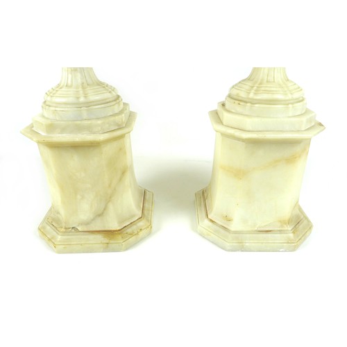 87 - A pair of Italian 19th century alabaster urns, raised on pedestals on an octagonal base, the handles... 