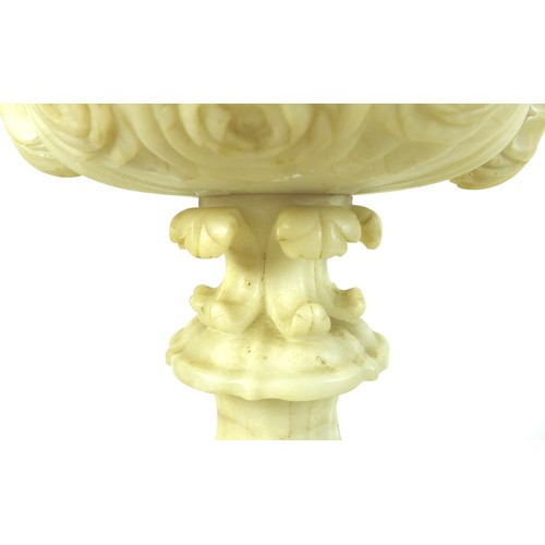 87 - A pair of Italian 19th century alabaster urns, raised on pedestals on an octagonal base, the handles... 