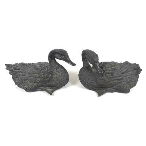 104 - A pair of 20th century cast resin duck sculptures, in resting positions, both approximately 30cm lon... 