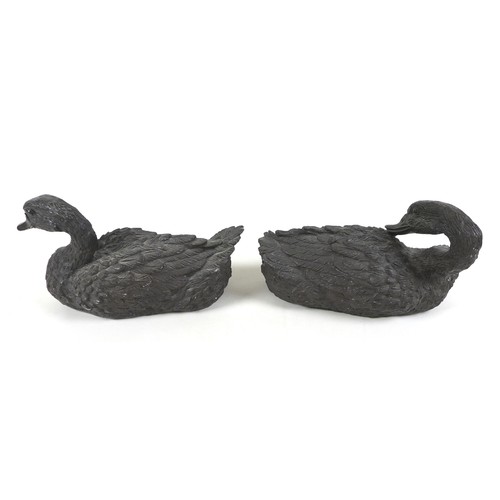 104 - A pair of 20th century cast resin duck sculptures, in resting positions, both approximately 30cm lon... 