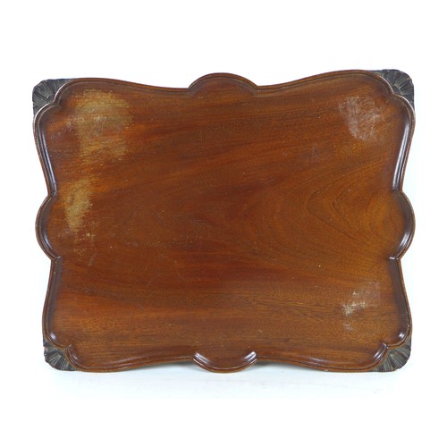 93 - A set of three graduated mahogany trays, circa 1900, shaped with carved edges, labels to verso, larg... 