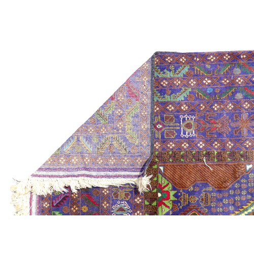 413 - A Persian rug with blue ground, unusual sectional orange and green medallion to the field, blue bord... 