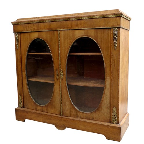 409 - A Victorian walnut veneered pier cabinet, gilt metal mounted, caddy top above two doors with oval gl... 