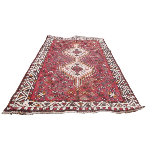 416 - A group of three rugs, comprising a Tekke rug with red ground and eleven offset rows each of twelve ... 