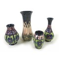 A group of four pieces of Moorcroft, comprising a 'Cluny' patterned vase, of waisted cylindrical for... 