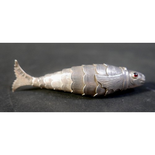 15 - An Edwardian silver novelty box, in the form of an articulated fish, with single red stone cabochon ... 