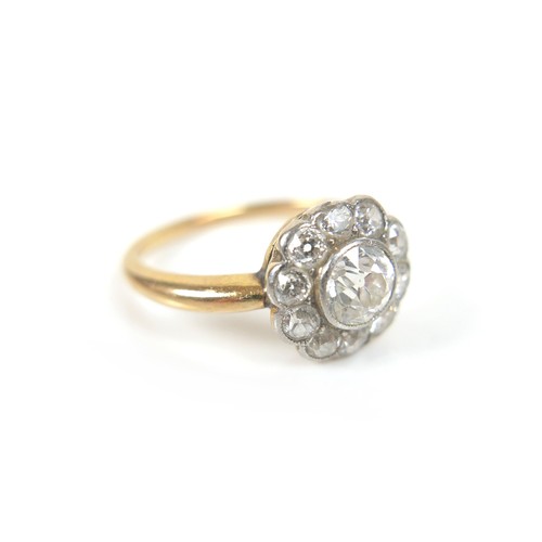 201 - An 18ct gold diamond daisy set ring, central stone approximately 5mm in diameter, surrounded by ten ... 