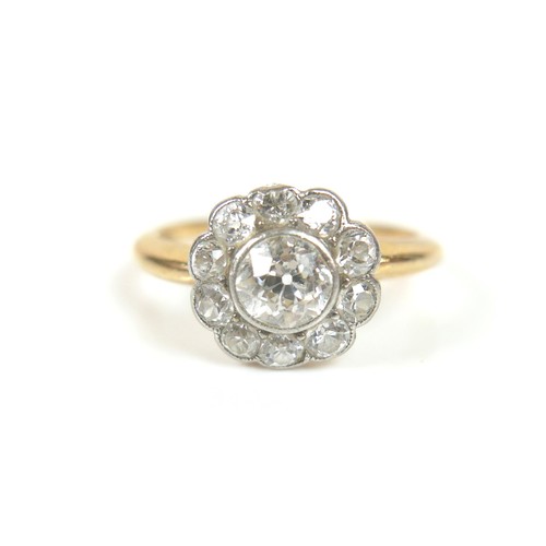 201 - An 18ct gold diamond daisy set ring, central stone approximately 5mm in diameter, surrounded by ten ... 